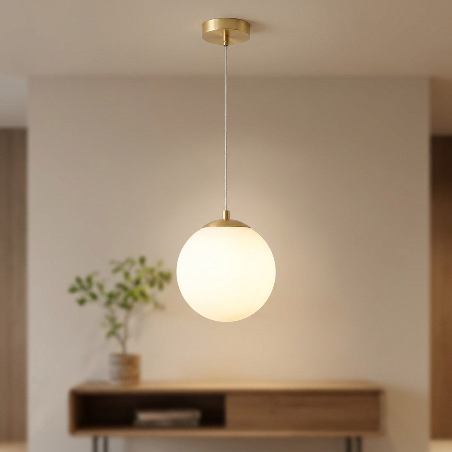 Suspension globe en verre opale à finition dorée allumée