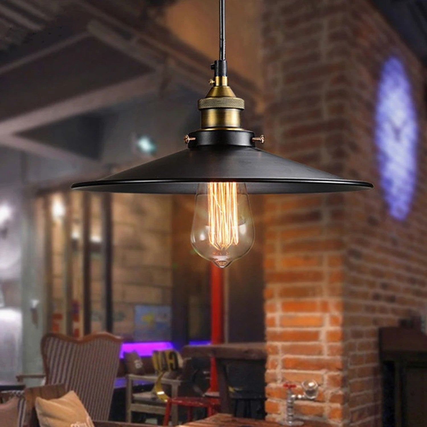 Suspension industrielle noire allumée dans un café au mur de briques