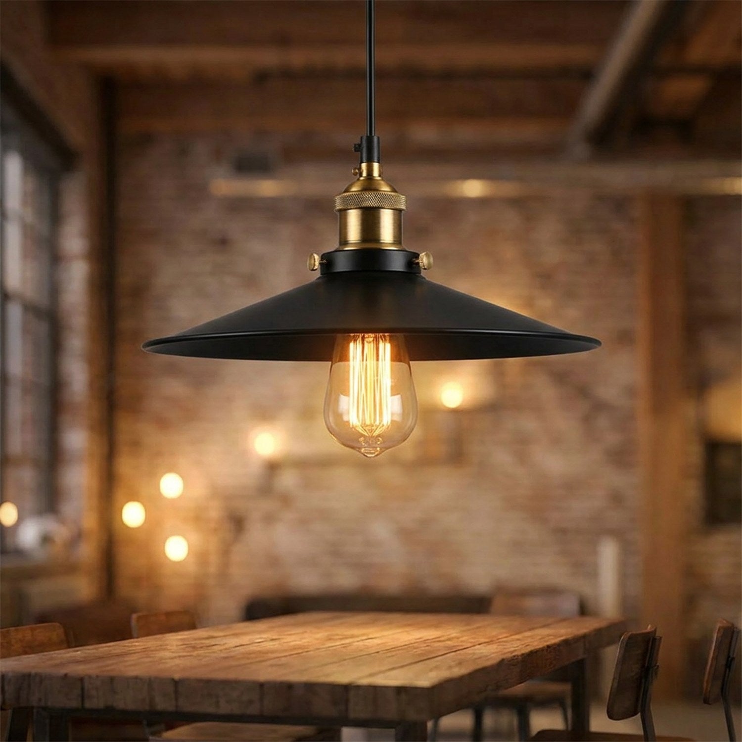 Suspension industrielle vintage en métal noir avec ampoule à filament allumée au-dessus d'une table en bois