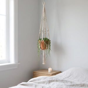 Suspension macramé blanche dans une chambre scandinave avec plante suspendue