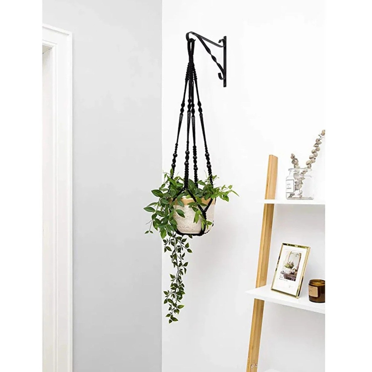 Suspension macramé blanche tenant une plante en pot dans une décoration intérieure