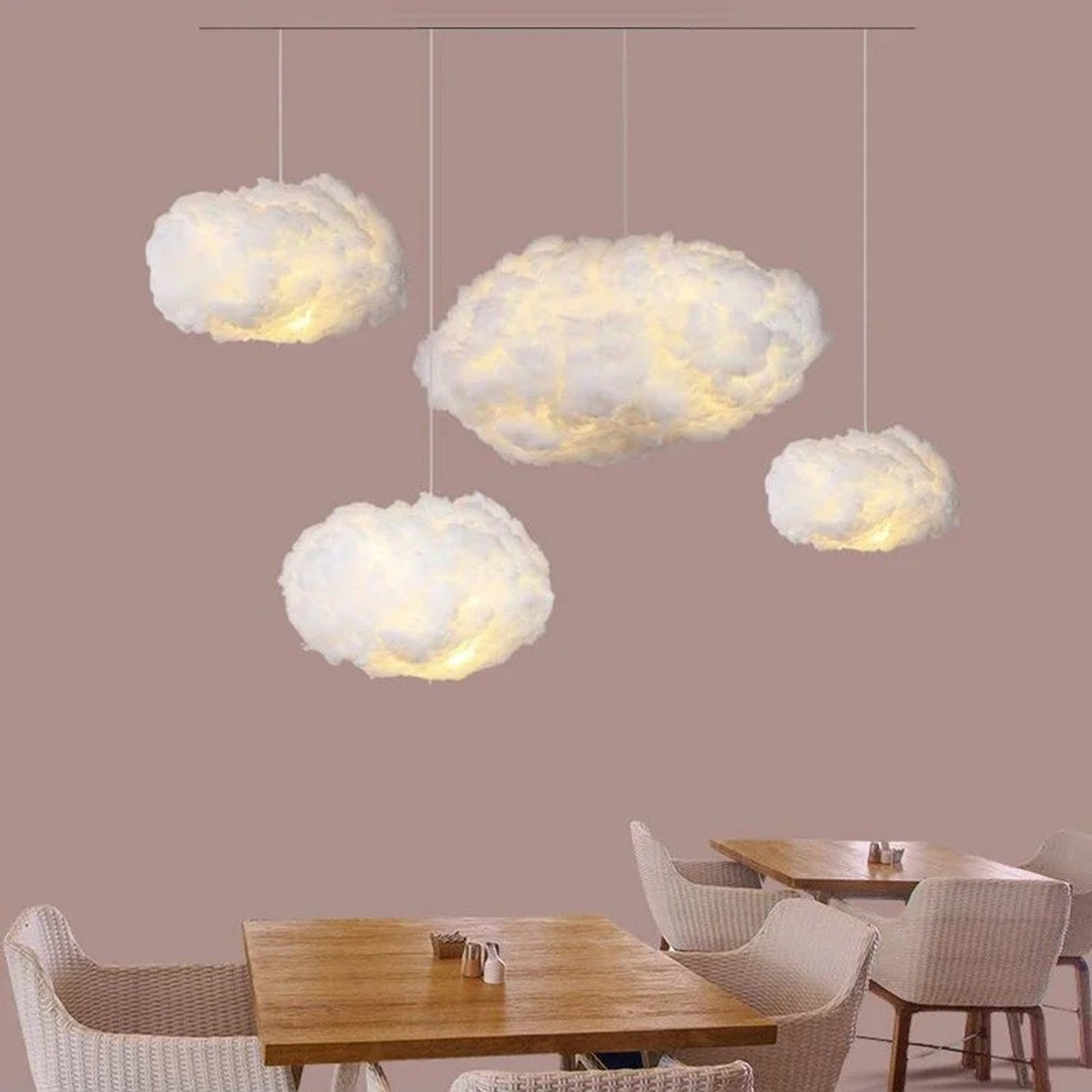 Plusieurs suspensions nuage LED allumées dans un restaurant aux tons chauds