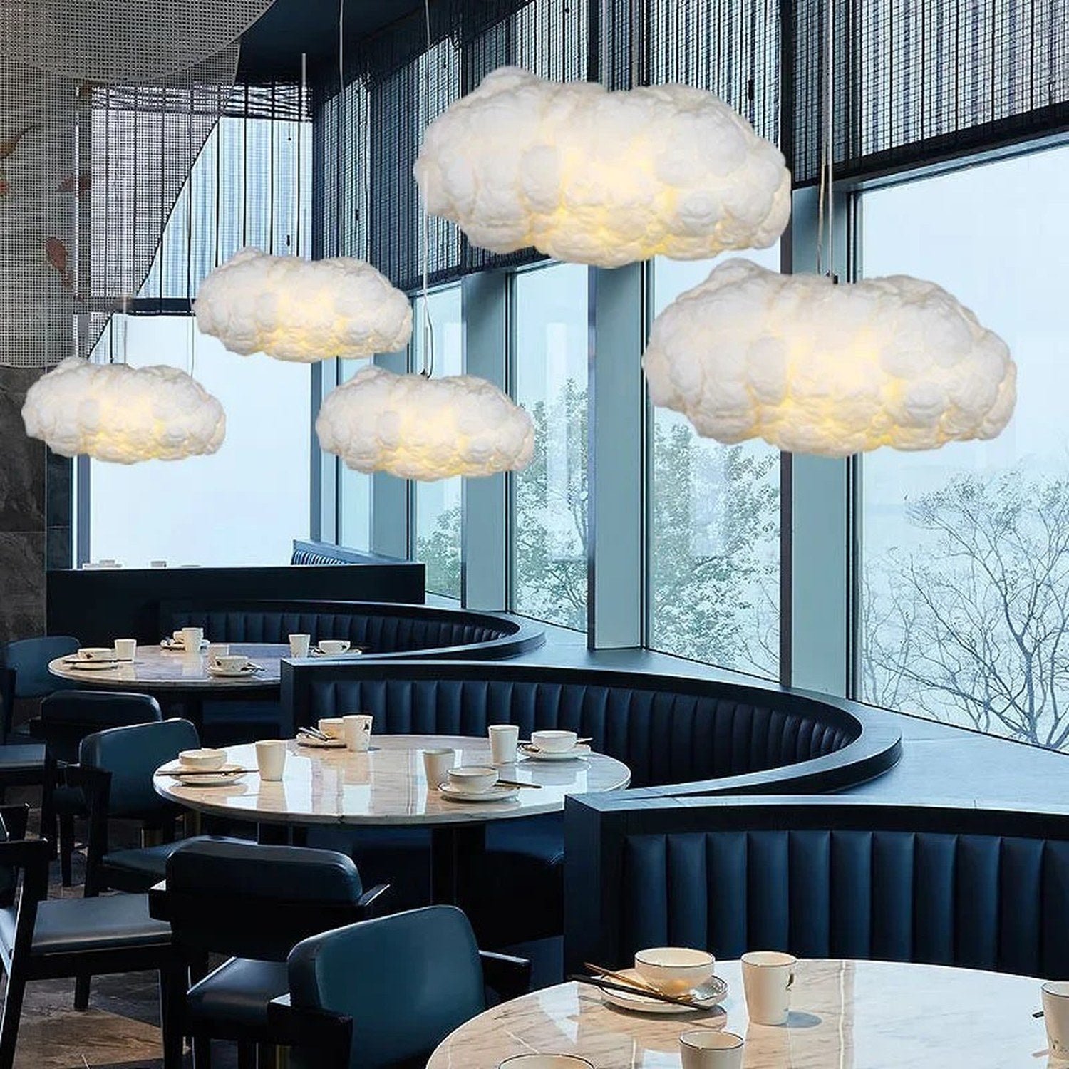 Multiples suspensions nuage LED dans un restaurant aux tons bleutés