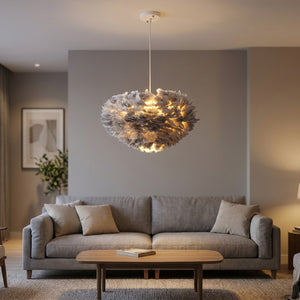 Suspension en plumes grises allumée dans un salon moderne au-dessus d'un canapé gris