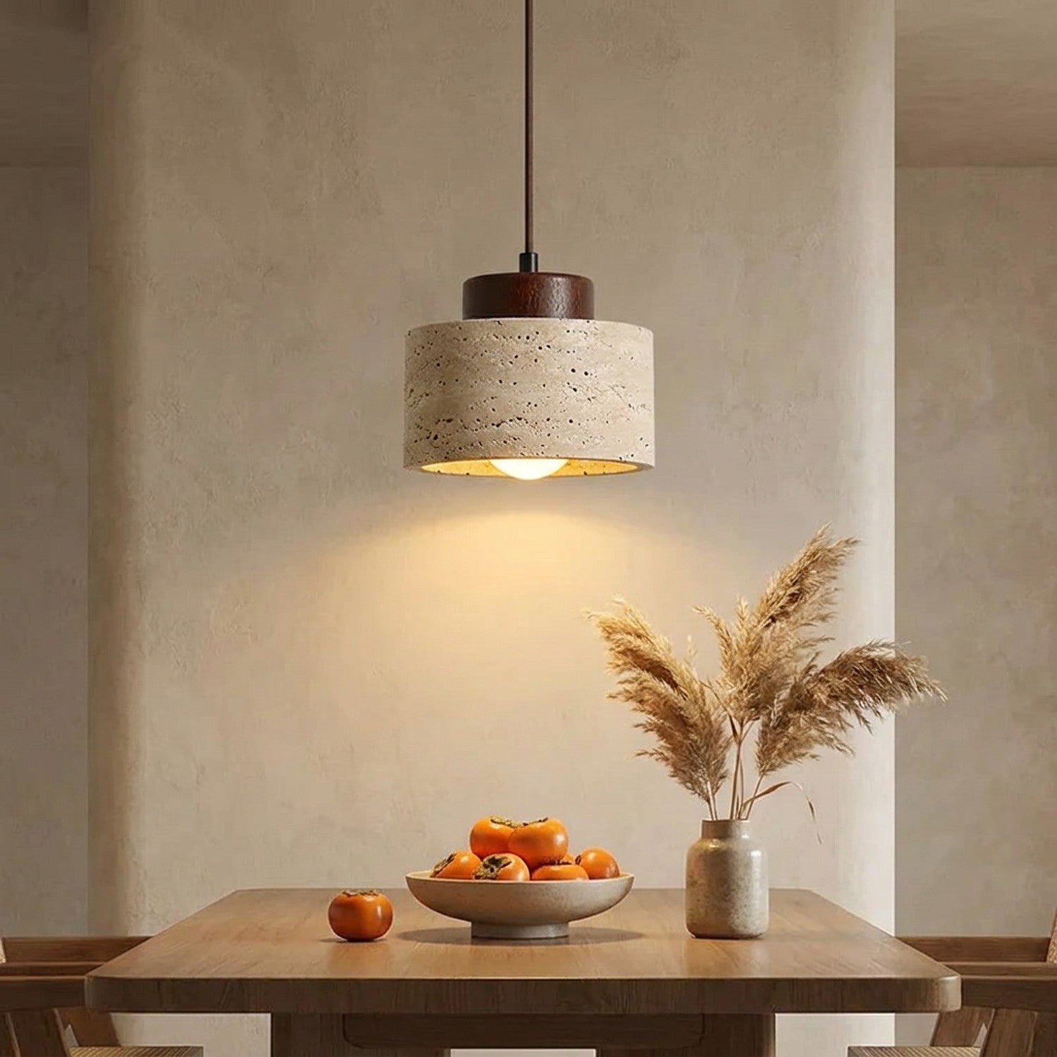Suspension travertin japonaise wabi-sabi au-dessus d'une table en bois avec kaki et herbe de la pampa