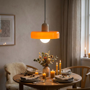 Suspension en verre orange allumée au-dessus d'une table de repas intime le soir