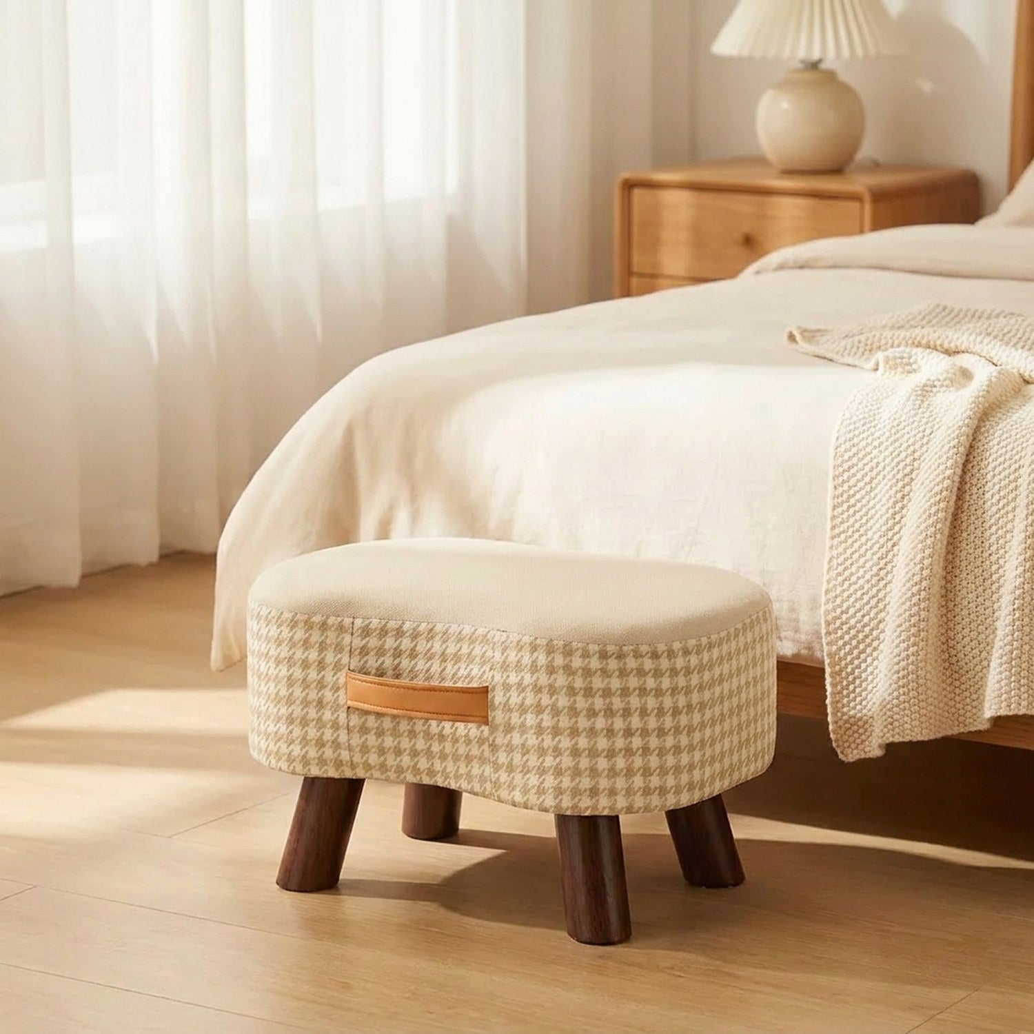 Tabouret beige au pied d'un lit dans une chambre lumineuse