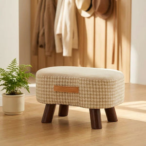 Tabouret beige dans une entrée avec plante verte et patère