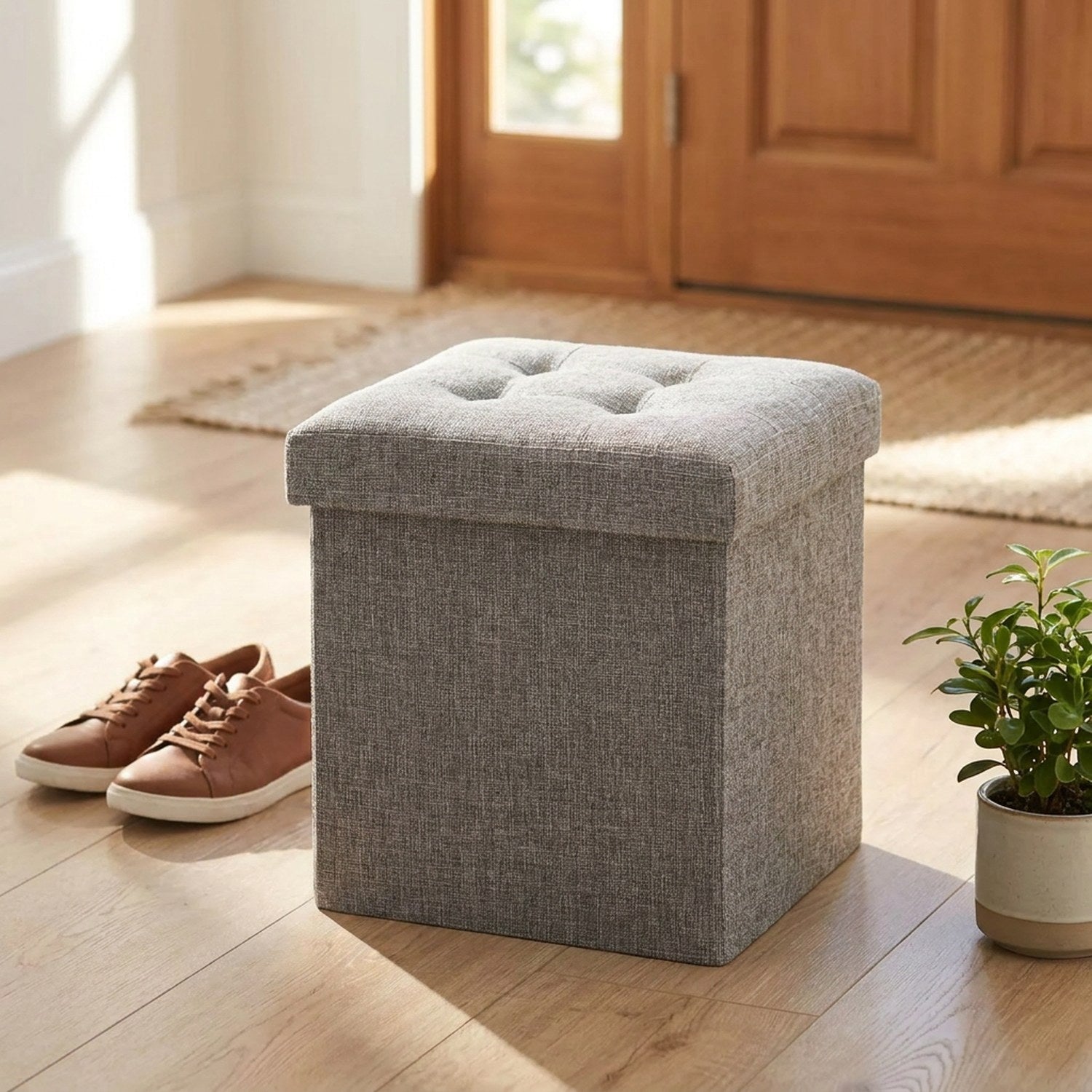 Tabouret coffre de rangement dans une entrée près de chaussures et d'une plante