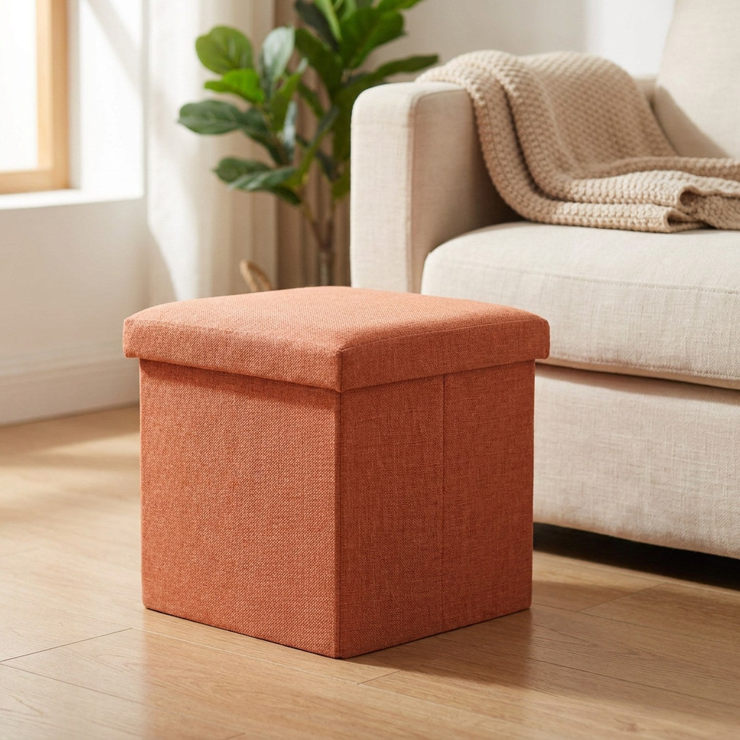 Tabouret de rangement pliable orange en tissu dans un salon