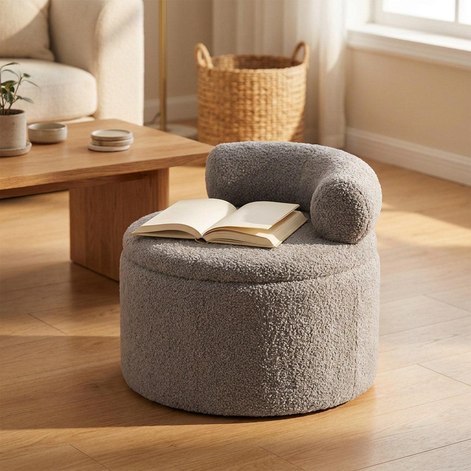 Tabouret pouf rond en bouclette grise utilisé comme repose-livre près d'une table basse