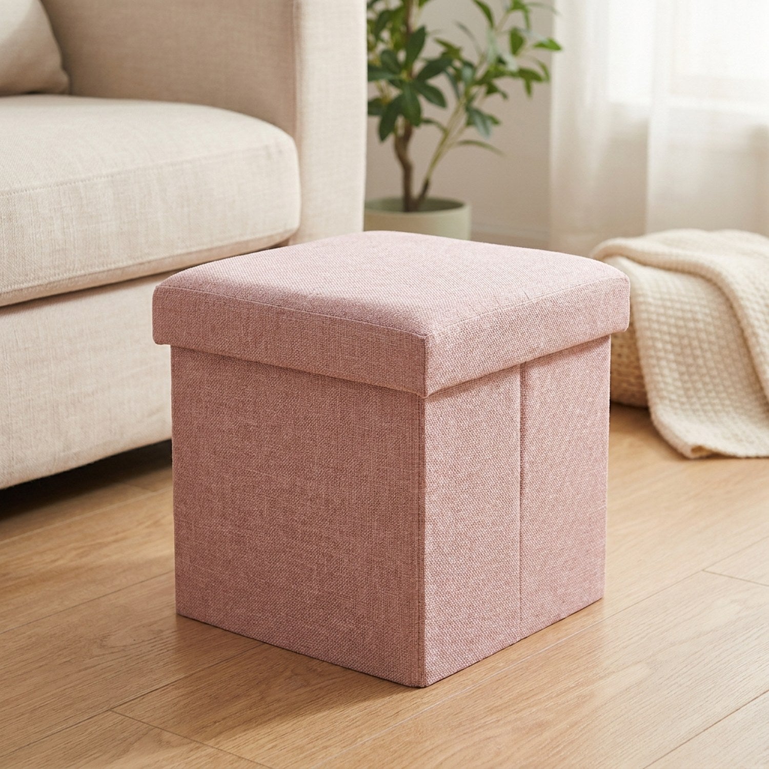 Tabouret de rangement pliable rose en tissu dans un salon