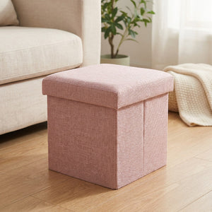 Tabouret de rangement pliable rose en tissu dans un salon