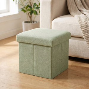 Tabouret de rangement pliable vert sauge en tissu dans un salon