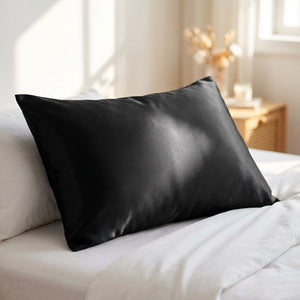 Taie d'oreiller en satin noir soyeux avec fermeture éclair sur un lit