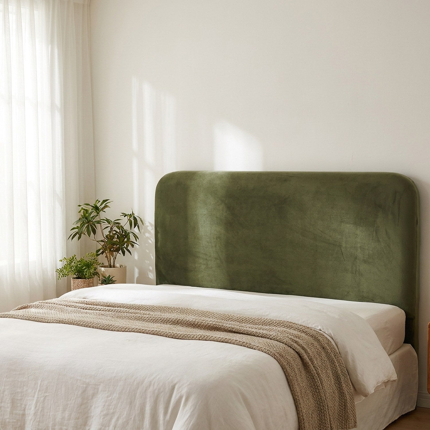 Housse de tête de lit verte en velours vue de côté dans une chambre scandinave