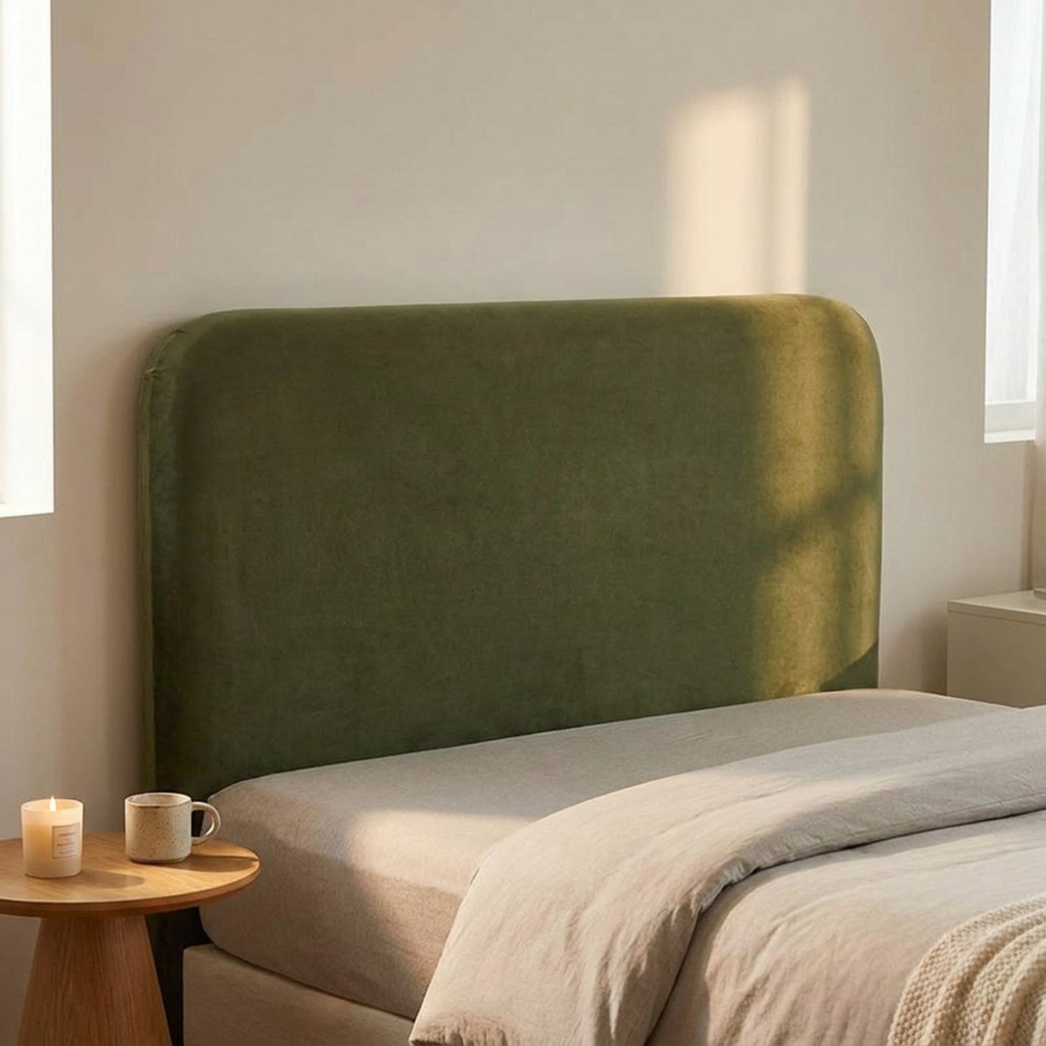 Housse de tête de lit verte en velours dans une chambre minimaliste avec table d'appoint