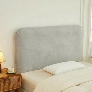 Housse de tête de lit gris clair en velours installée dans une chambre