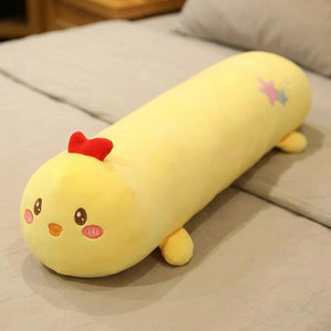 Traversin peluche en forme de poussin kawaii posé sur un lit clair