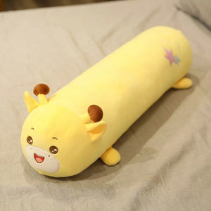 Traversin peluche en forme de girafe kawaii posé sur un lit clair