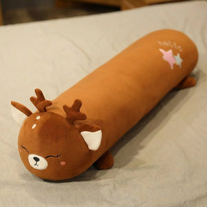 Traversin peluche en forme de cerf kawaii posé sur un lit clair