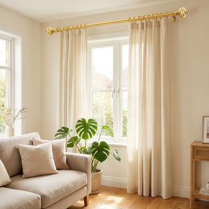 Tringle à rideaux dorée installée au-dessus d'une fenêtre de salon avec rideaux crème