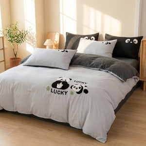 Parure de lit panda grise en coton motif Lucky sur un lit dans une chambre enfant lumineuse