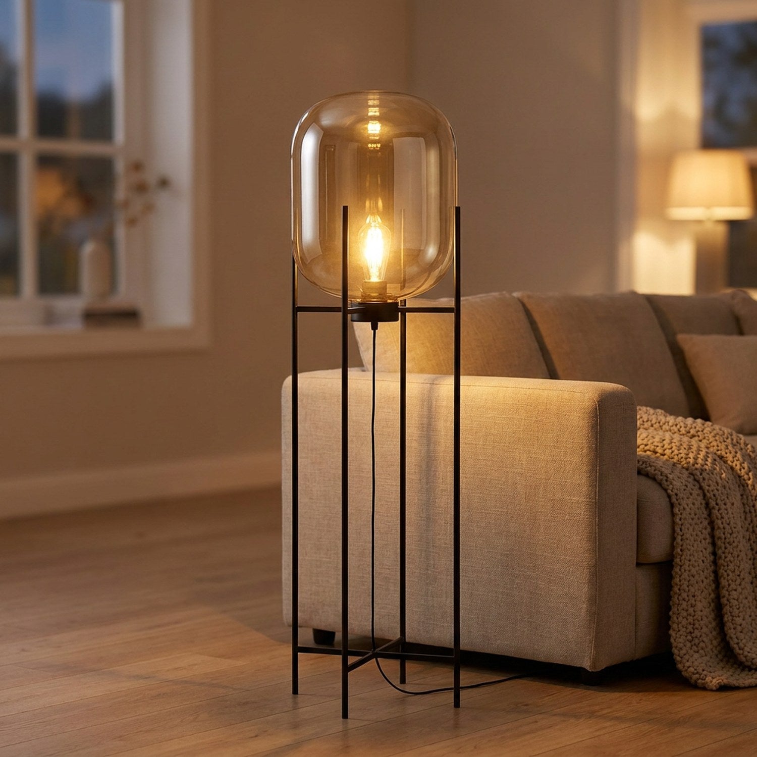 Lampadaire nordique globe en verre ambré allumé sur pied métal noir dans un salon chaleureux