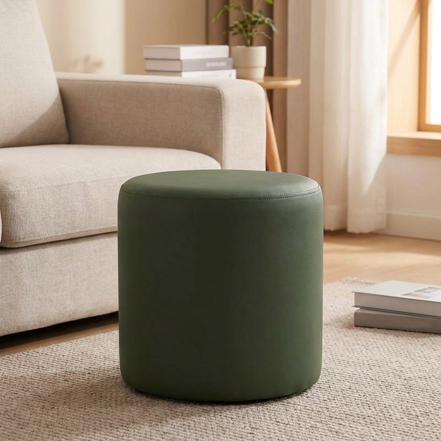 Tabouret pouf rond vert olive posé sur un tapis près d'un canapé