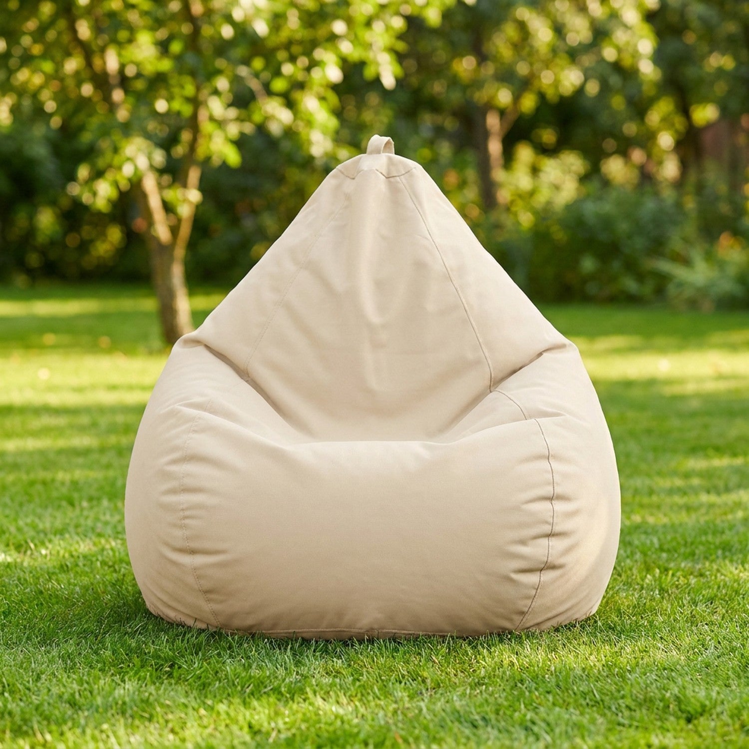 Housse de pouf poire beige sur une pelouse de jardin