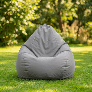 Housse de pouf poire grise posée sur une pelouse verte