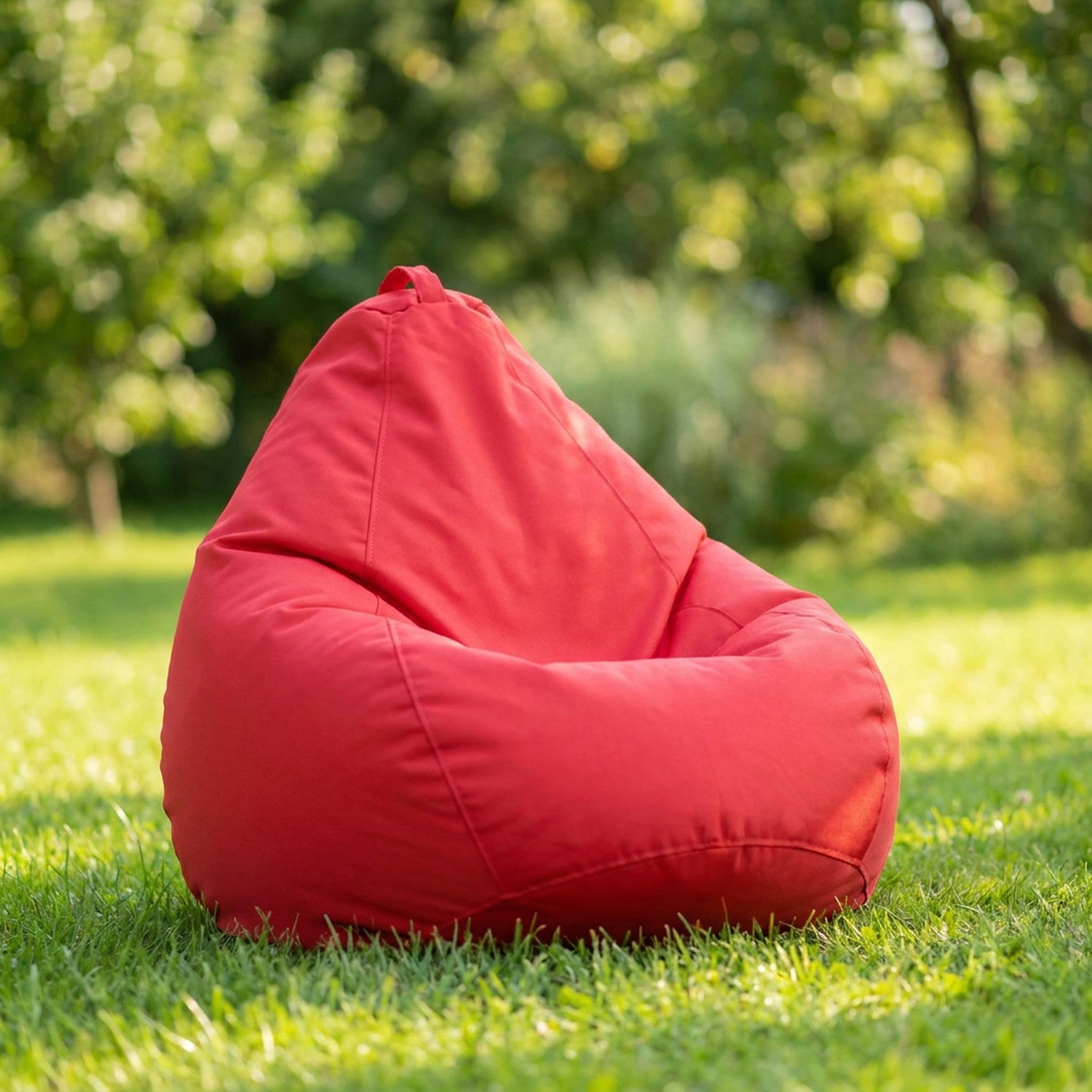 Housse de pouf poire rouge sur une pelouse de jardin
