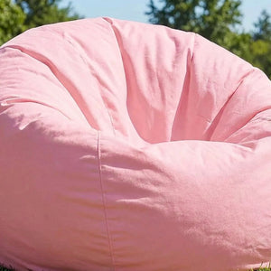 Housse de pouf poire rose dans un jardin verdoyant