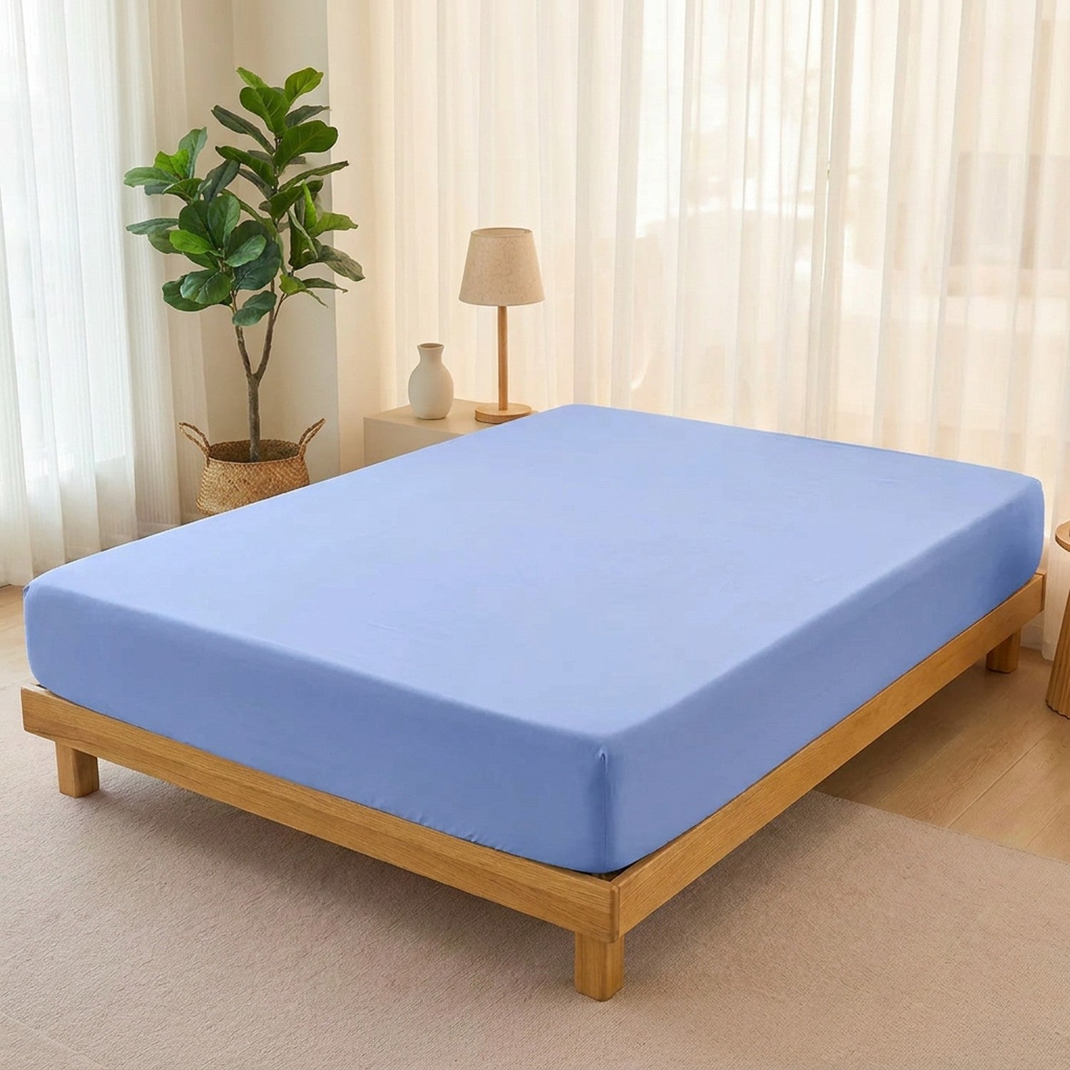 Drap-housse bleu extensible sur un lit en bois dans une chambre claire et aérée
