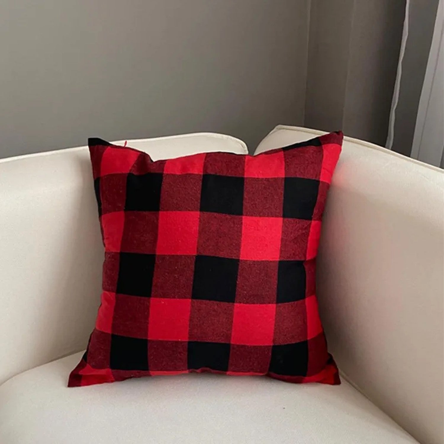Housse de coussin à carreaux rouge et noir sur un fauteuil