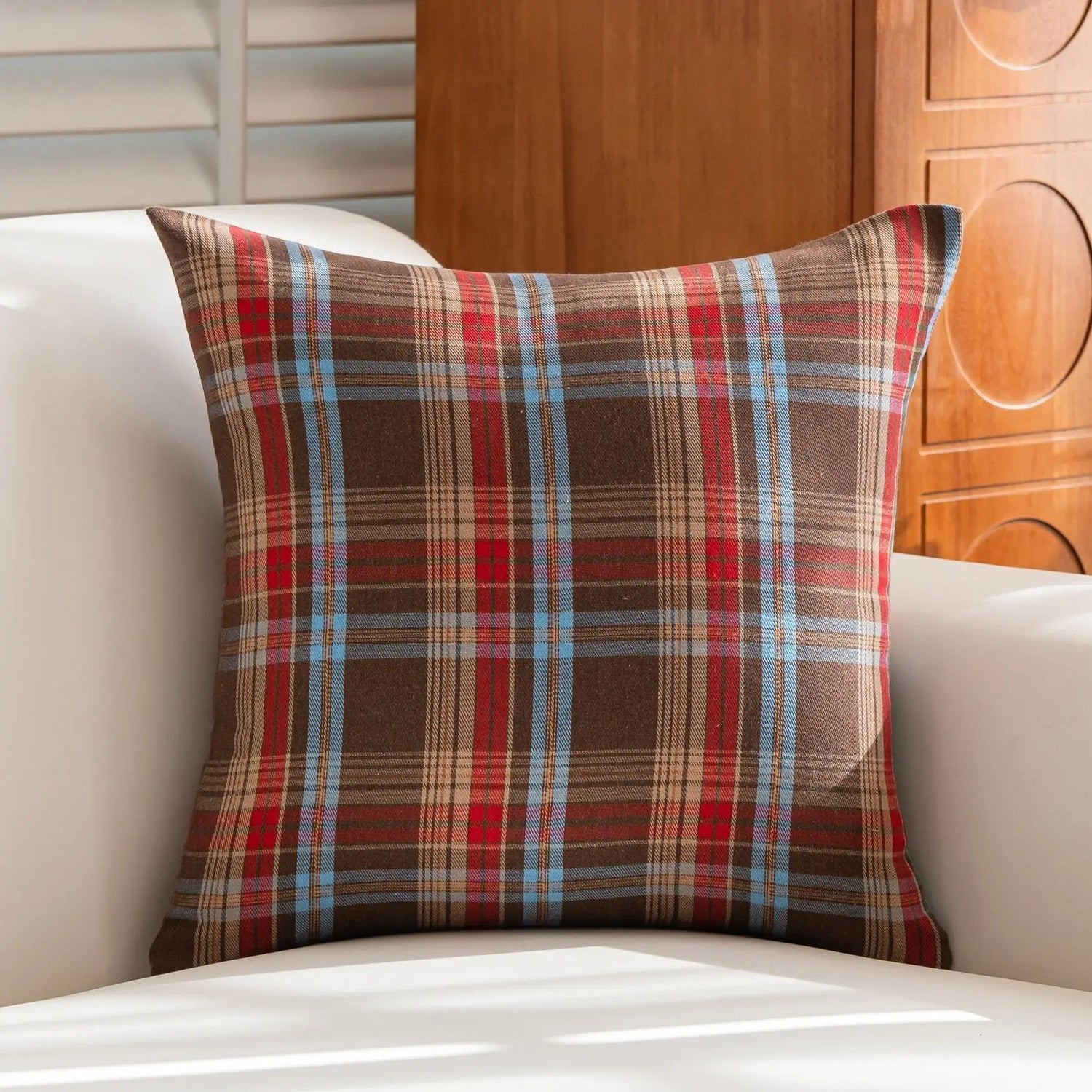 Housse de coussin à carreaux tartan beige sur un canapé