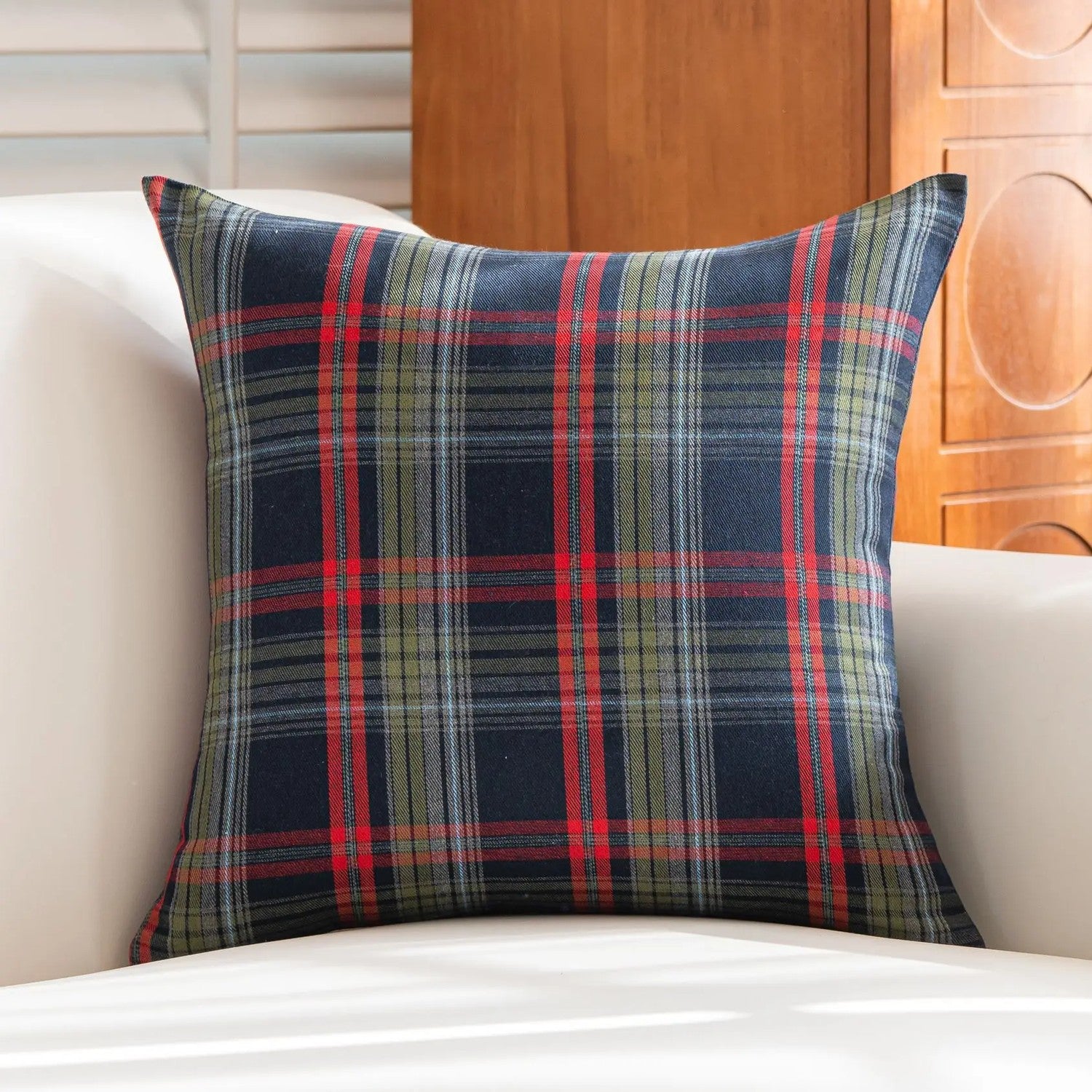 Housse de coussin de Noël à carreaux tartan bleu foncé sur un canapé