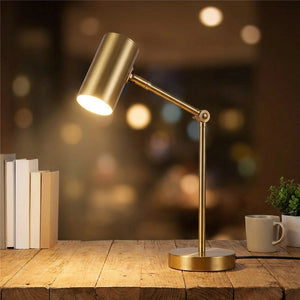 Lampe de bureau dorée modèle bras articulé allumée