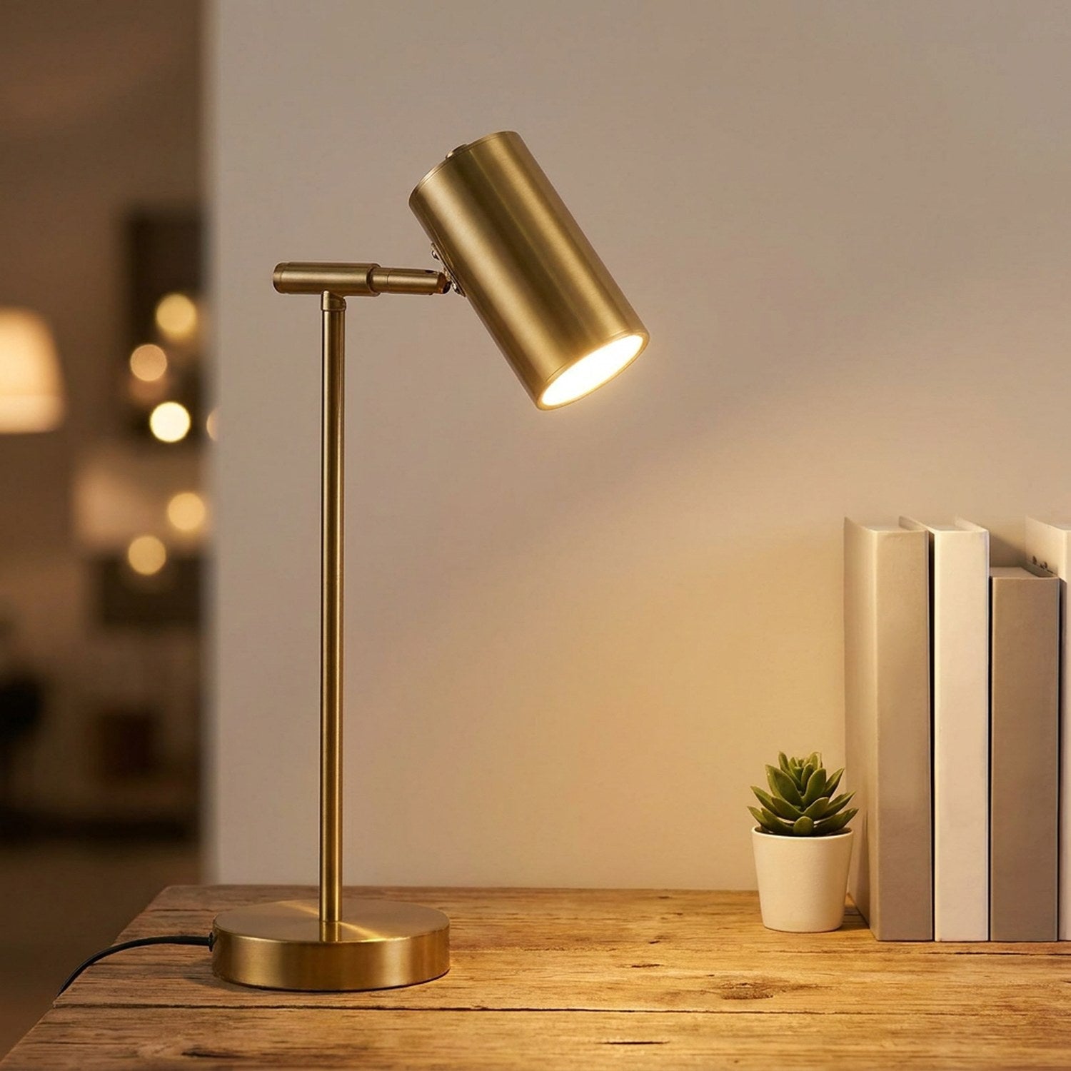 Lampe de bureau dorée modèle bras droit allumée