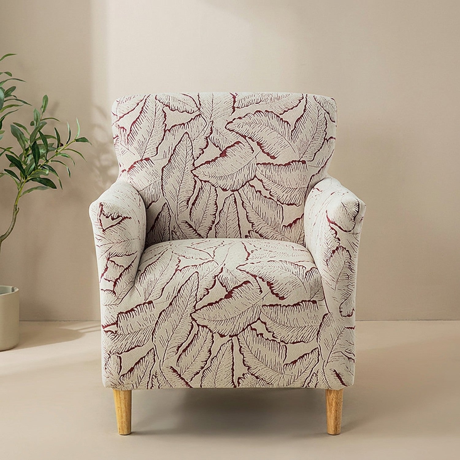 Housse de fauteuil bordeaux à motif de feuilles en jacquard sur un fauteuil club
