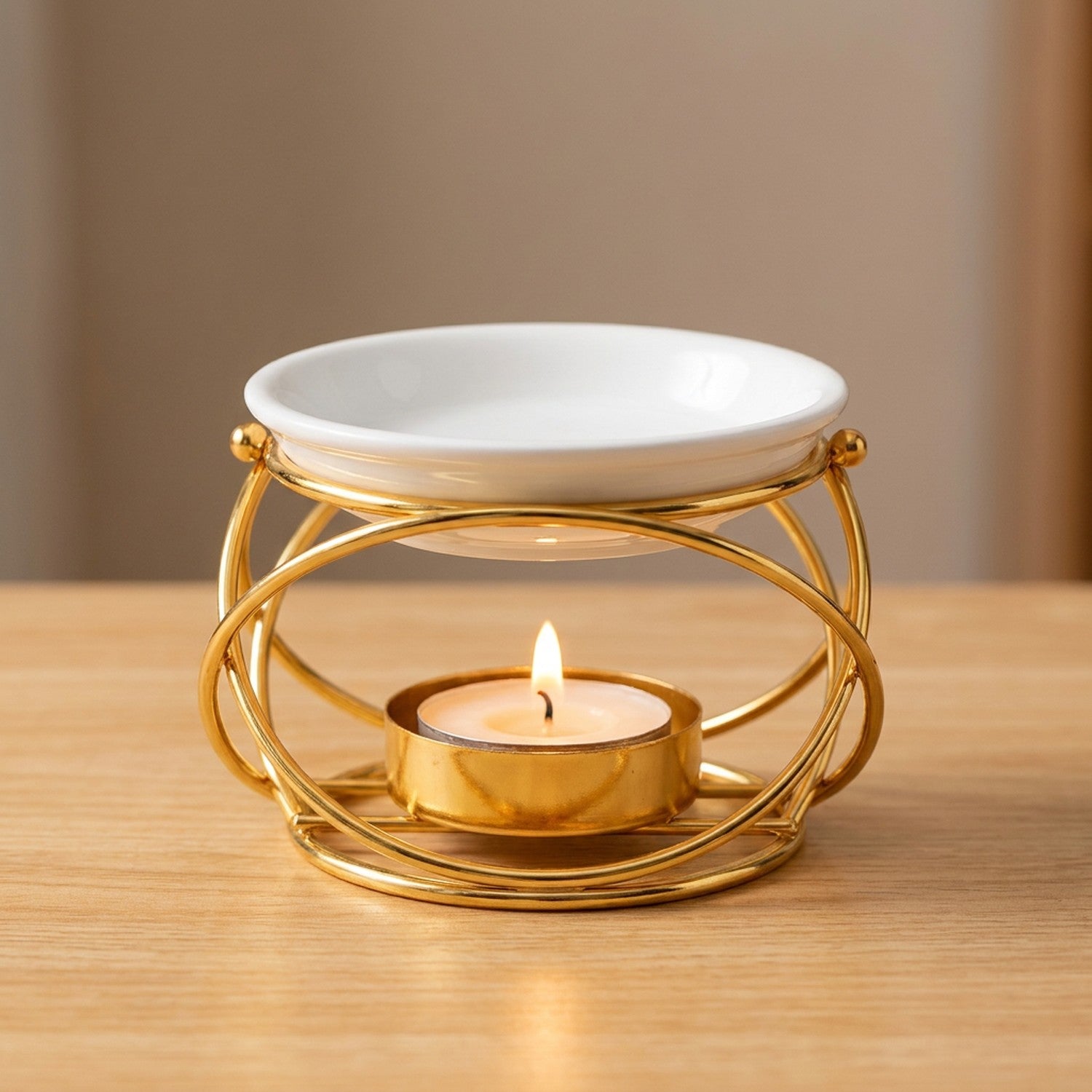 Brûleur d'huile essentielle modèle Sphère en finition dorée avec bougie allumée