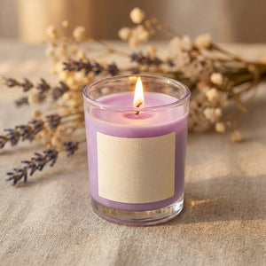 Bougie parfumée violette en cire de soja allumée sur une nappe en lin