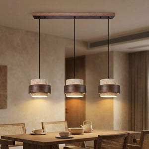 Suspension beige trois lampes sur barre en bois au-dessus d'une table