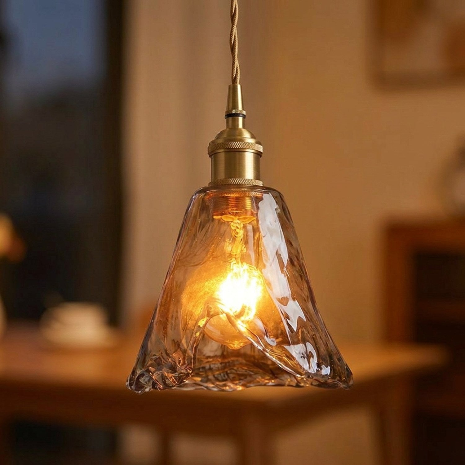 Suspension rétro en verre ambré ondulé forme cloche allumée dans un intérieur chaleureux