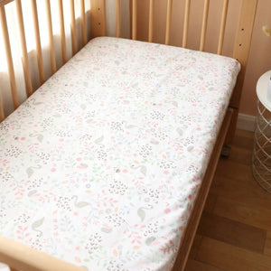 Drap housse bébé motif cygne rose et fleurs sur un matelas de berceau