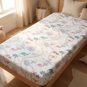 Drap housse bébé motif dinosaures pastel sur un matelas de berceau