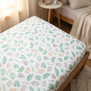 Drap housse bébé motif feuilles vertes sur un matelas de berceau