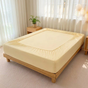 Drap-housse jaune pâle extensible sur un lit dans une chambre claire et aérée