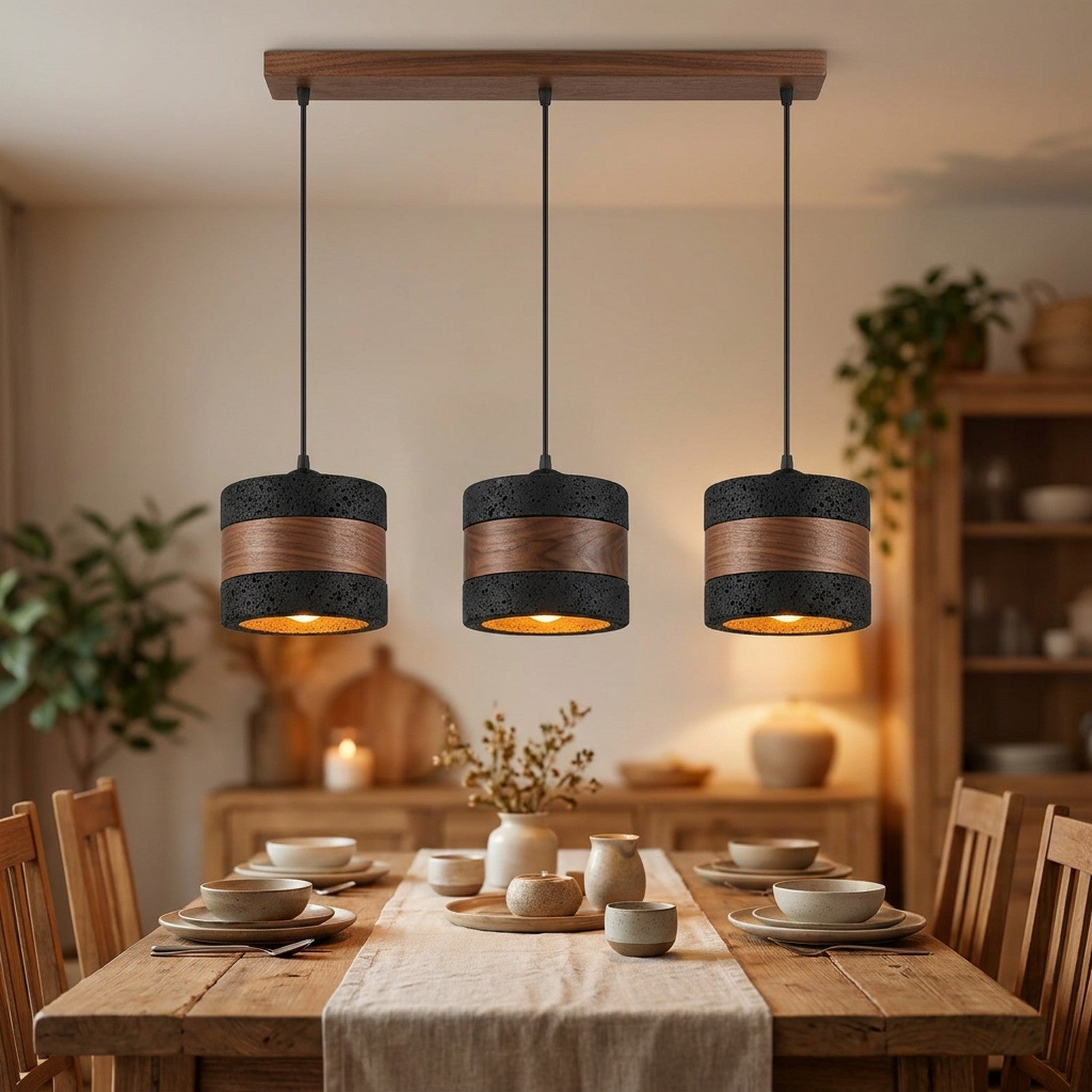 Suspension noire trois lampes sur barre en bois au-dessus d'une table