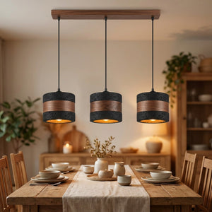 Suspension noire trois lampes sur barre en bois au-dessus d'une table